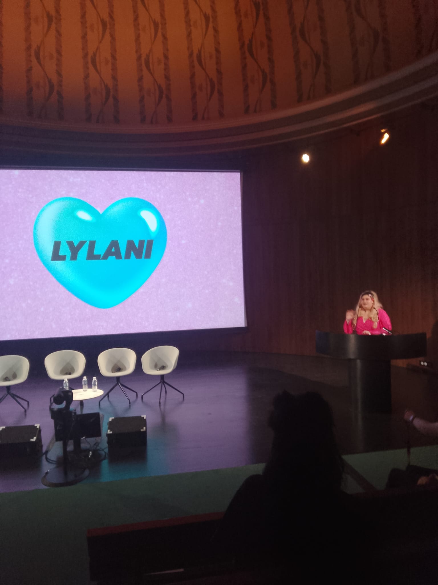 Lylani on the V&A stage, with her personal logo on the screen